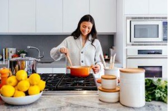 Woman enjoying while preparing a meal in her cozy kitchen.