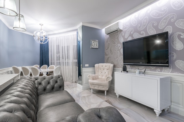 A grey leather sofa placed in front of a TV